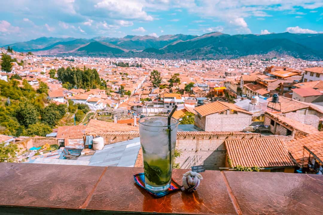 A refreshing Pisco Sour enjoyed on a terrace, offering a scenic view of Cusco, Peru's captivating cityscape.